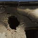 A hole where a missile hit is seen above the destroyed window of the outpatient department.